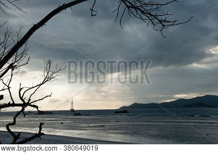 Dramatic Sky With Clouds And Sunbeam Over The Indian Ocean With Sailing Boat During Sunset.