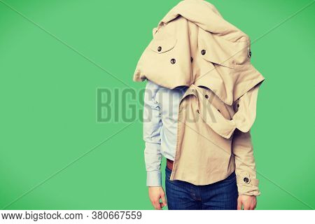 Man given up on trying to put a coat on as it on his head