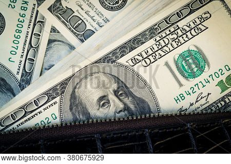 Fragment Of 100 Dollar Bills A On Crocodile Leather Bag. Close Up Of American Currency. Us Dollar Ba