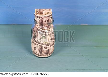 Saving 100 Dollar Bill Money In Glass Jar. Money In A Pot. Home Economy. Close Up Of American Curren