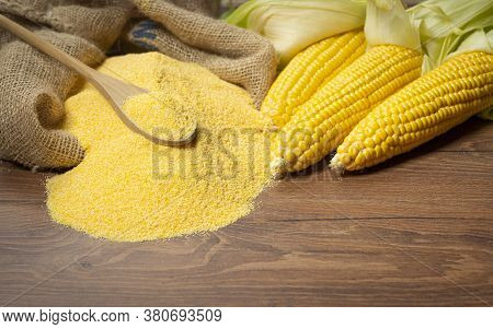 Ripe Young Sweet Corn Cob,on Left Stack Cornmeal And Spoon On Top,wooden Background, Copy Space.glut