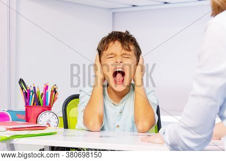 Boy With Autism Disorder Scream And Close Ears In Pain During Aba Development Therapy Sitting By The
