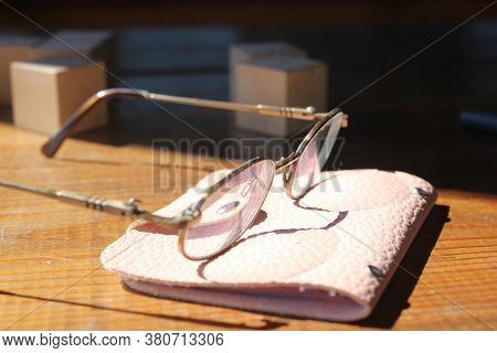 Glasses, And Pink Leaher Wallet On Wooden Table. Business Profit Concept