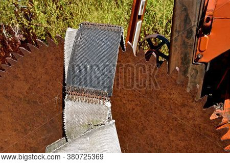 A Huge Rusty Saw Blade Is Mounted On A Tractor With A Leather Belt To Be Attached To The Belt Pulley