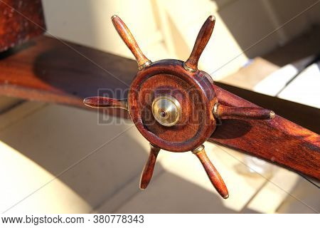 Close-up Of The Steering Wheel Of The Ship As A Decoration. The Ship's Wheel Is On The Deck.