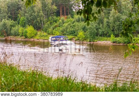 A Speedboat Moves Slowly Along The Moscow Canal. Journey, A White Motor Yacht Slowly Moves Along The