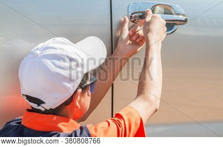 Close-up Of Person's Young Man Locksmith Hand Opening Bronze Car Door With Lock Picker. Locksmith Do