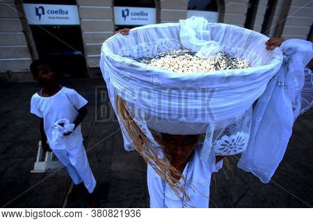 Salvador, Bahia / Brazil - August 15, 2018: Young Candomble Supporter Carries The Basket Of Popcorn 