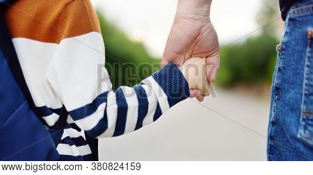 Little Boy With His Father Going To School After Summer Break. Close-up Photo Of Child And Parent Ha