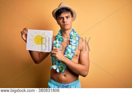 Tourist man on vacation wearing swimwear and hawaiian lei flowers holding banner with sun with a confident expression on smart face thinking serious