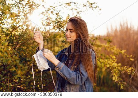 Woman With Medical Mask On A Tree. Virus. Freedom.