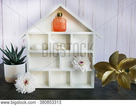A White House Shadowbox With Flowers, Stones And Essential Oil