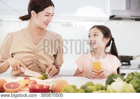 Happy Mother And Child Daughter  Preparing The Vegetables And Fruit In Kitchen
