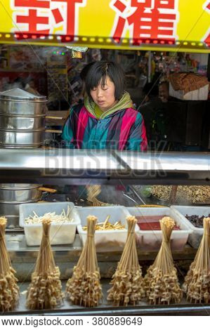 Luoyang, Henan Province / China - January 3, 2016: Vendor Girl Selling Snacks At A Street Food Stall