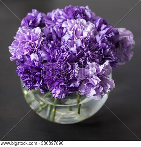 Bridal Bouquet Of Lilac Carnations In A Round Glass Vase As Table Decoration