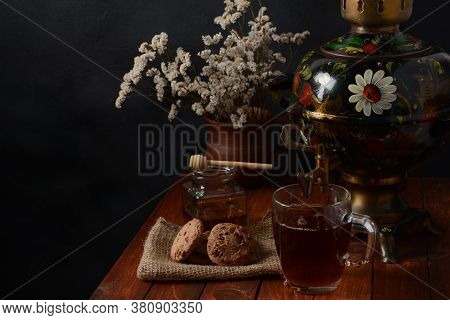 Tea Party In Rustic Style With Samovar\na Glass In Glass Holder, Honey And Cookies