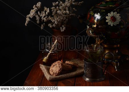 Tea Party In Rustic Style With Samovar\na Glass In Glass Holder, Honey And Cookies