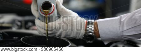 Close-up Of Car Mechanic Replacing And Pouring Fresh Oil Into Engine At Maintenance Repair Service S