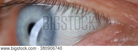 Close-up Of Senior Man Eye With Beautiful Blue Colour. Person Looking Away. Macro Shot Of Tiny Wrink