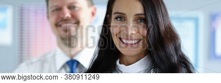 Portrait Of Business Partners Posing On Camera In Office. Businesspeople In Presentable Suits Smilin