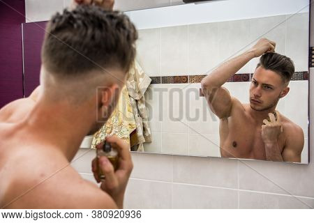 Handsome Young Man In Bathroom, Spraying Cologne