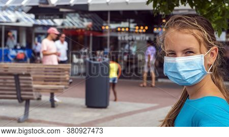 A Young Girl Wears A Face Mask On The Streets Of The City.cute Teenage Girl With A Surgical Mask On 