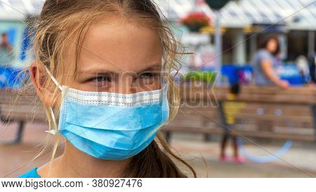 A Young Girl Wears A Face Mask On The Streets Of The City.cute Teenage Girl With A Surgical Mask On 