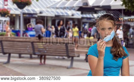 A Young Girl Wears A Face Mask On The Streets Of The City.cute Teenage Girl With A Surgical Mask On 