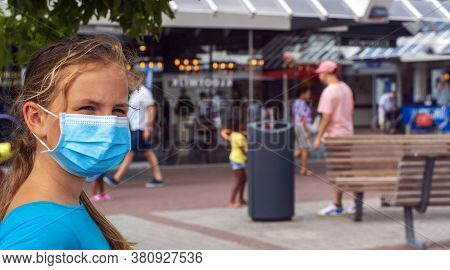 A Young Girl Wears A Face Mask On The Streets Of The City.cute Teenage Girl With A Surgical Mask On 