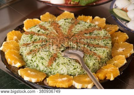Moroccan Traditional Cuisine: Grated Cucumber Salad With Cinnamon, Garnished With Oranges.