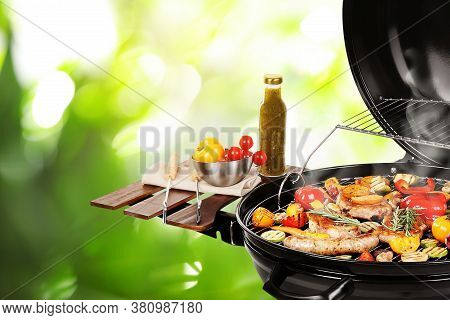 Barbecue Grill With Meat Products And Vegetables On Blurred Green Background, Closeup
