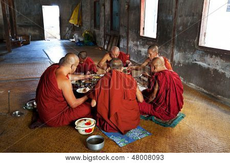 NYAUNGSHWE, MYANMAR - FEBRUARY 2: Buddhist monks have the scanty dinner in Shwe Yan Pyay on February 2, 2011 in Nyaungswe, Shan, Myanmar. The Buddhism is important part of social life in the Myanmar.