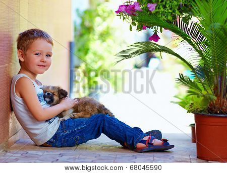 Smiling Boy With Sleeping Puppy In Hands