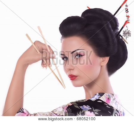 Young woman in Japanese kimono with chopsticks and sushi roll, isolated on white background.