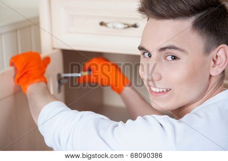 Young man assembling furniture