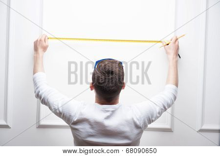 Young handsome worker with measuring tape