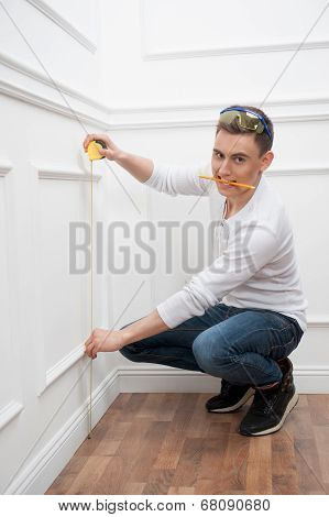 Young handsome worker with measuring tape