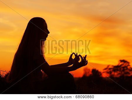 beautiful young girl doing yoga at sunset