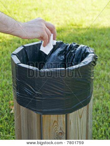 Hand kasta skrynkligt papper i litterbin.