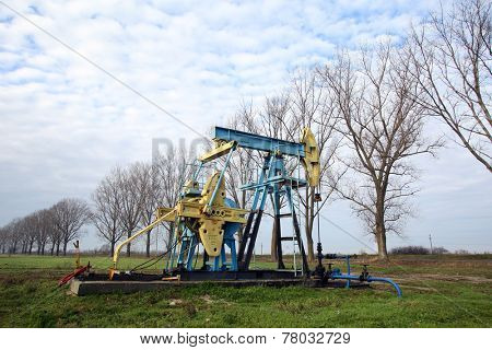 ARAD, ROMANIA - FRIDAY, DECEMBER 5, 2014: A pumpjack pumps oil out of the ground at a production field operated by OMV Petrom S.A, the largest gas and oil producer in Eastern Europe 