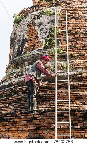 Worker At Temple Area In Ayutthaya Climbing A Stupa