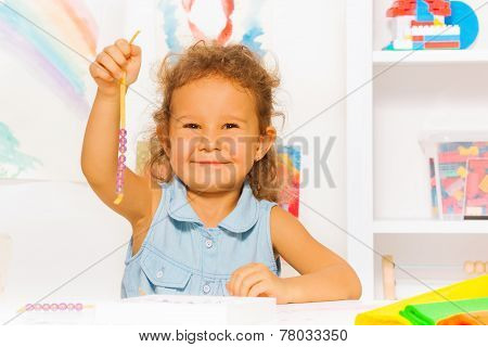 Happy little girl with beads on a string