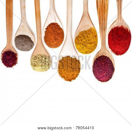 Assortment of powder spices on spoons isolated on a white background