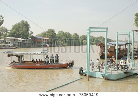 Ferry carrying motorcycle crossing river