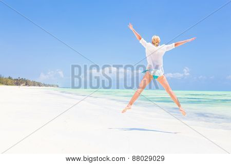 Beautiful Girl Jumping on Tropical Beach.