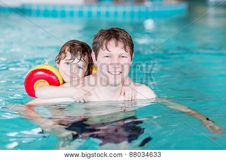 Young Dad Teaching His Little Son To Swim Indoors