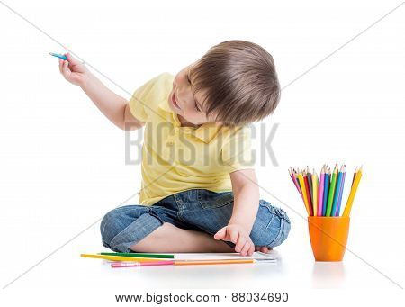 Happy kid drawing with pencils in album