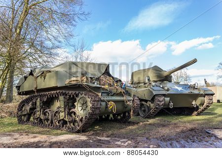 Two green military tanks with blue sky