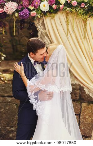 Wonderful Stylish Rich Happy Bride And Groom Higing Kissing At A Wedding Ceremony In  Garden