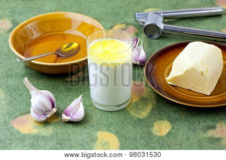 home made remedy for flu: glass of hot milk with honey butter and garlic